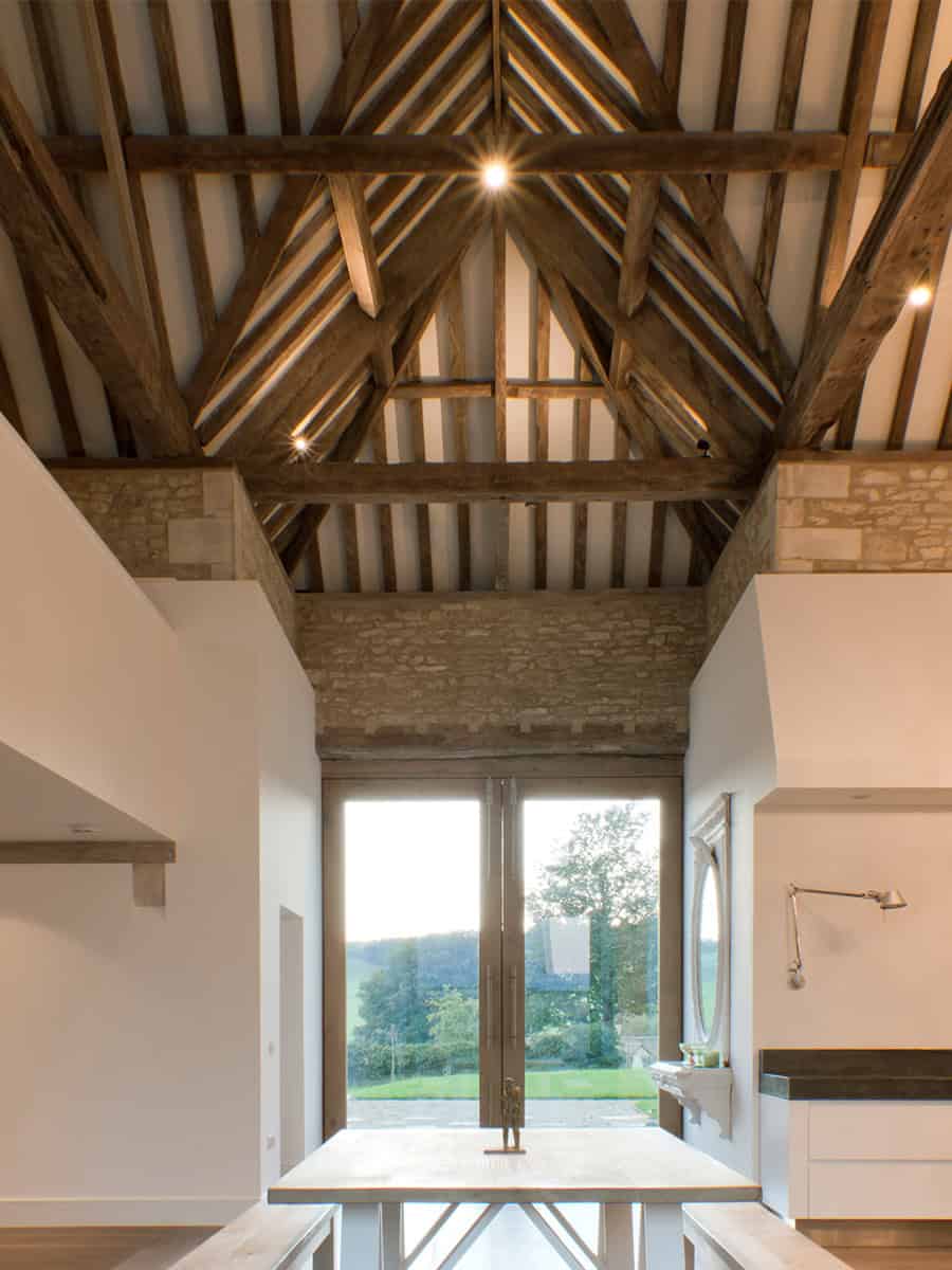 Vale Farm vaulted interior with exposed oak roof trusses and Cotswold stone walls, Gloucestershire